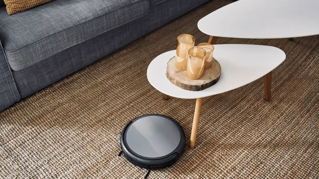 An image of a high end robot vacuum cleaning an expensive carpet while not spilling the drinks on the coffee table. 