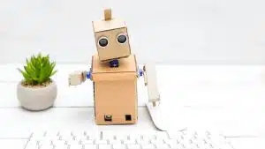 An image of a clean white desktop, with keyboard and small plant, for the desktop robots article.