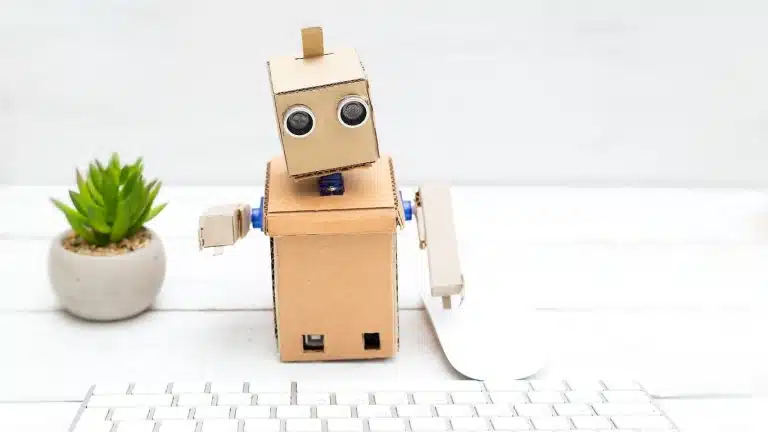 An image of a clean white desktop, with keyboard and small plant, for the desktop robots article.